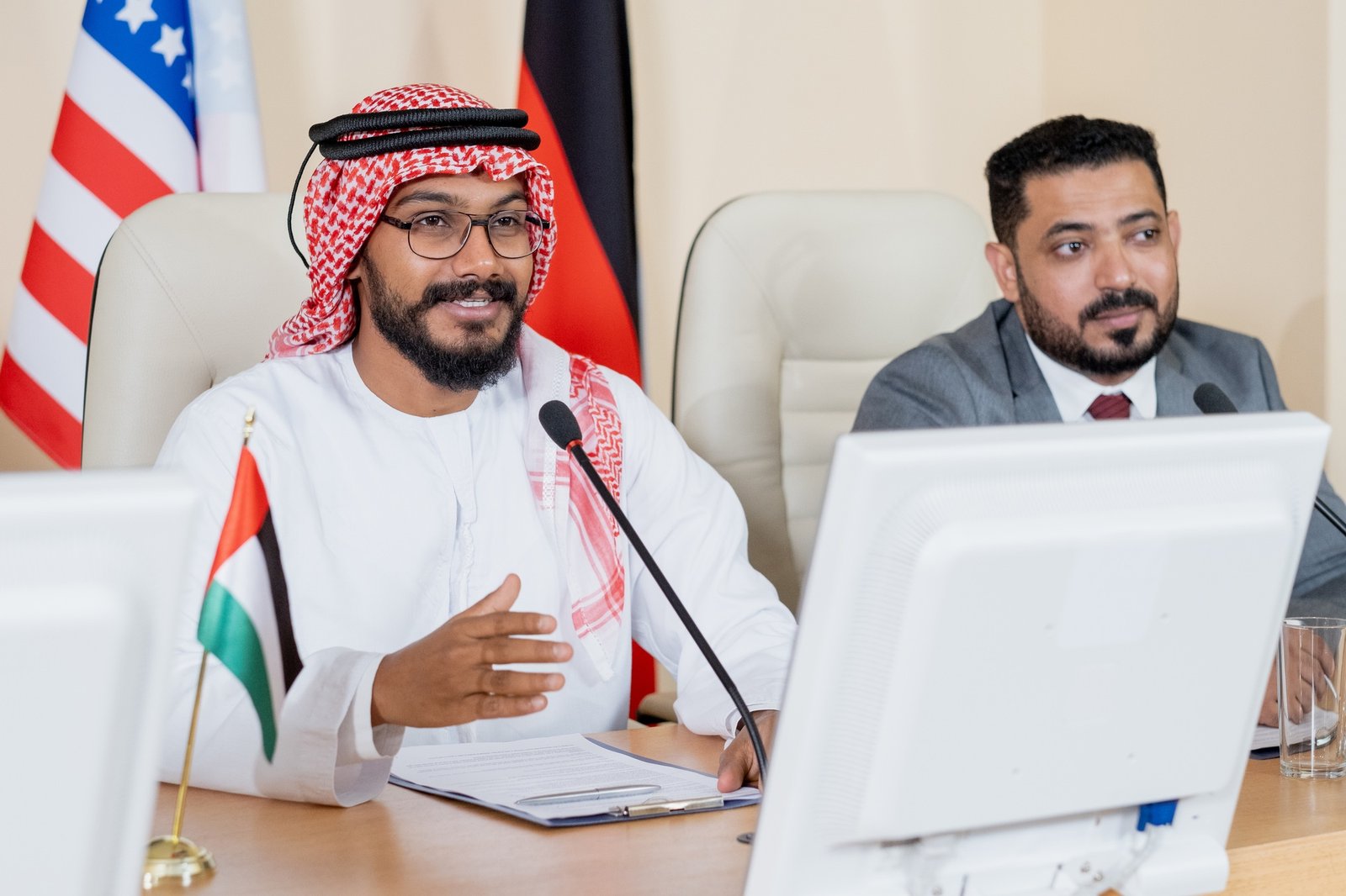 Young confident Arabian delegate speaking in microphone at conference